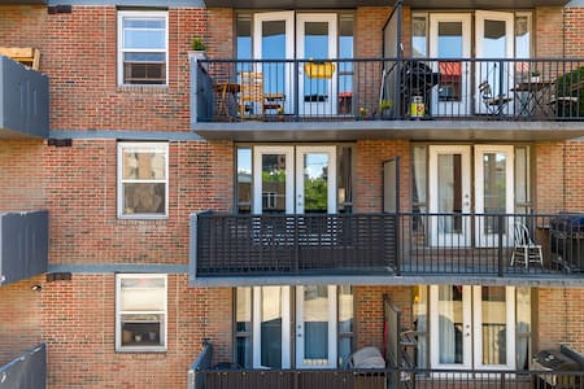 Un edificio residencial de varios pisos con fachadas de ladrillo, ventanas amplias y balcones.