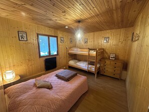 A wooden cabin bedroom with bunk beds, a television, and framed pictures on the walls. - At the base of a chalet at the foot of the slopes in the Pierre Saint Martin ski resort. (Arette)