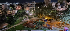 Ein Nachtblick auf eine Wohngegend mit Spielplatz, Straßenlaternen und Gebäuden.