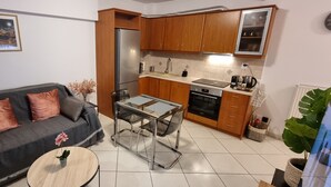 Ein Wohnzimmer mit einer Couch, einem Couchtisch und einem Esstisch mit Glasplatte.