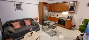 Ein Wohnzimmer mit einer Couch, einem Couchtisch und einem Esstisch mit Glasplatte.
