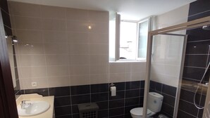 Een badkamer met een wastafel, toilet en douche.
