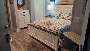 Ein Schlafzimmer mit Bett, Schminktisch, Spiegel und Deckenventilator.