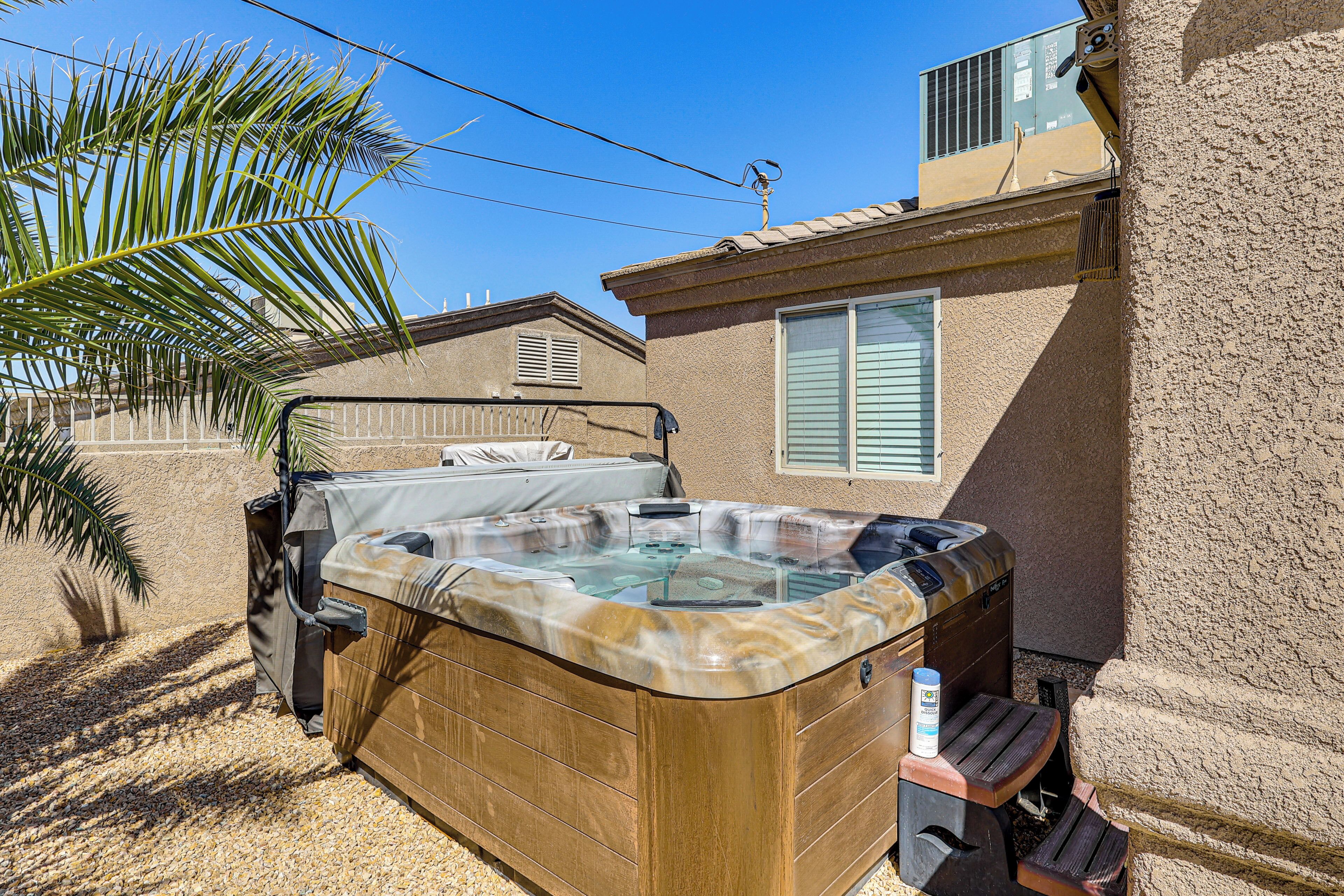 A hot tub in a backyard with a house in the background.