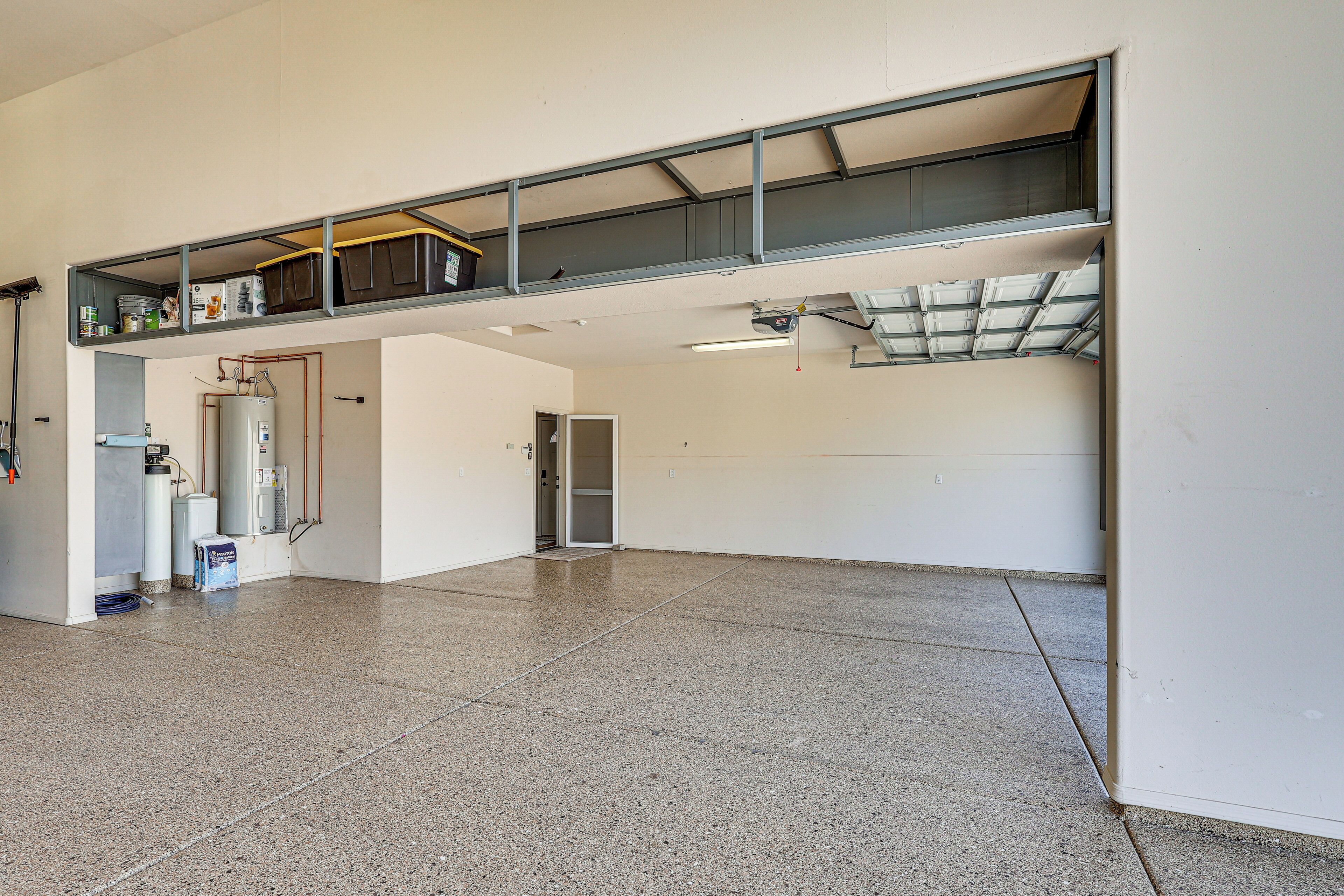 A spacious indoor area with a high ceiling, a water heater, and a door leading to another room.