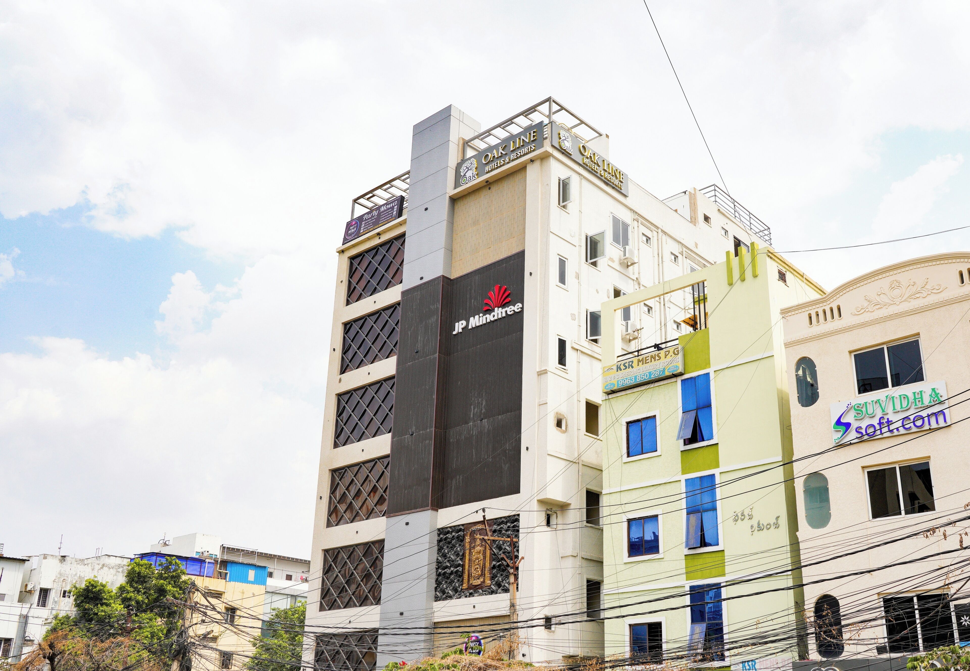 A multi-story building with signage for 'Oak Line Hotels & Resorts' and 'JP Mindtree.'