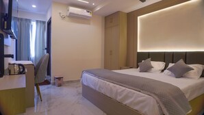 Ein modernes Hotelzimmer mit Bett, Nachttisch und Schreibtisch mit Stuhl.