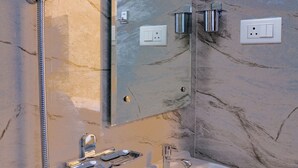 Ein Badezimmer mit Dusche, Waschbecken und Spiegel.