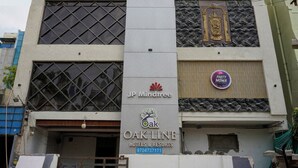 Ein mehrstöckiges Gebäude mit Beschilderung für 'JP Mindtree' und 'Oak Line Hotels & Resorts'.