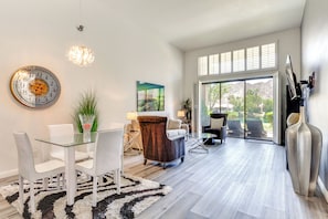 Ein modernes Interieur mit Essbereich, einem großen Fenster und Blick ins Freie.