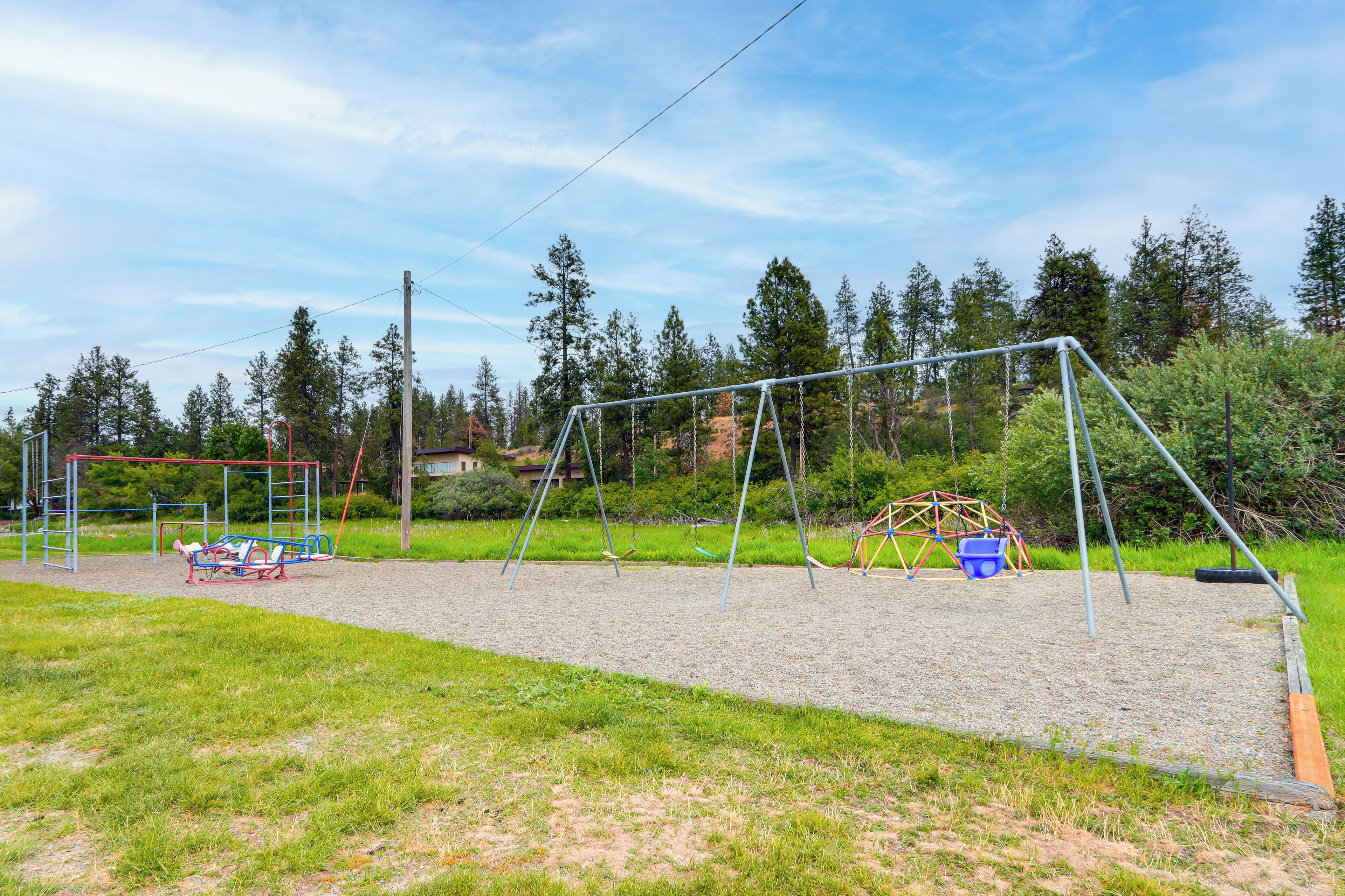 A playground with swings and a climbing structure.