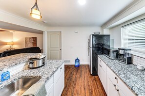 A kitchen with granite countertops, a stainless steel sink, a refrigerator, and a water dispenser. - 4 Mi to K-state! Modern Garden-level Apt (Manhattan)