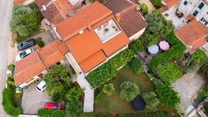 Vista aérea de uma área residencial com várias casas, uma piscina e um jardim.