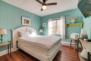 A bedroom with a bed, a ceiling fan, a window with curtains, a bedside table, and a wall-mounted shelf. - 2 Blocks to Ocean! North Wildwood Family Getaway (North Wildwood)
