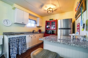 A kitchen with white cabinets, a stainless steel refrigerator, a clock, and a window with blue curtains. - 2 Blocks to Ocean! North Wildwood Family Getaway (North Wildwood)