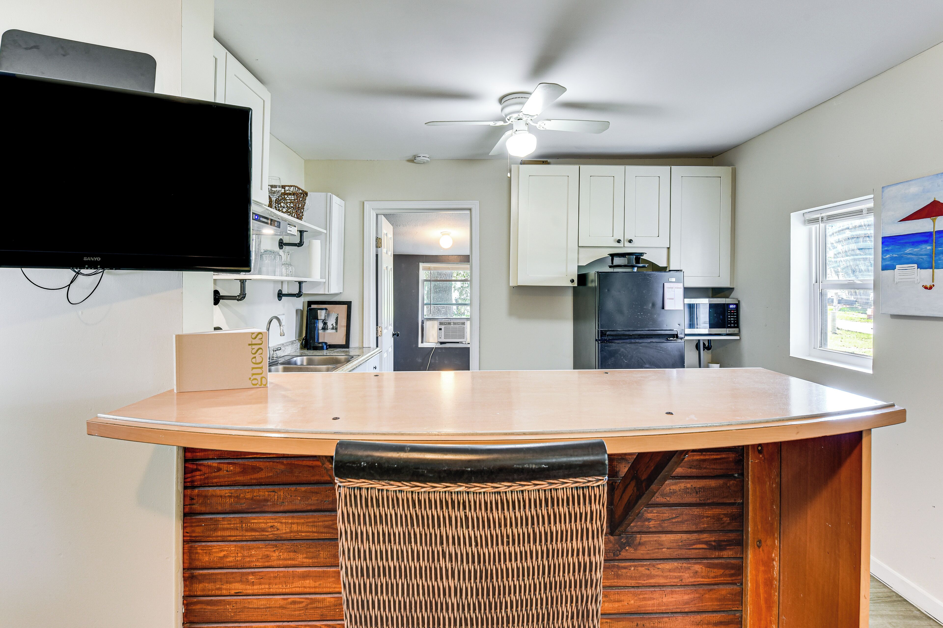 Une cuisine avec un coin bar, un ventilateur de plafond et une fenêtre avec vue.