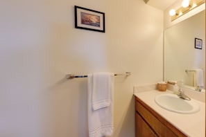 A bathroom with a white sink, a towel hanging on a rack, a framed picture on the wall, and a mirror with lights above it. - 2 Mi to River, Lake Mohave and Laughlin Casinos (Bullhead City)