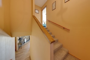 A staircase with a wooden handrail, carpeted steps, and a stone wall with a lamp and decorative items. - 2 Mi to River, Lake Mohave and Laughlin Casinos (Bullhead City)