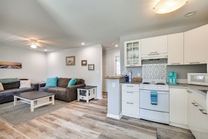 A modern kitchen with white cabinets, a stove, and a microwave. - Steps to Ocean! Family-friendly Carolina Beach Gem (Carolina Beach)