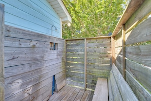Une terrasse en bois avec un bâtiment bleu en arrière-plan.