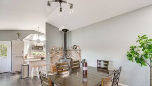 A dining area with a wooden table, chairs, and a potted plant. - Waterfront Union Getaway w/ Ocean & Mtn Views (Union)