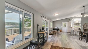 A spacious living area with large windows, a dining area, and a kitchen. - Waterfront Union Getaway w/ Ocean & Mtn Views (Union)
