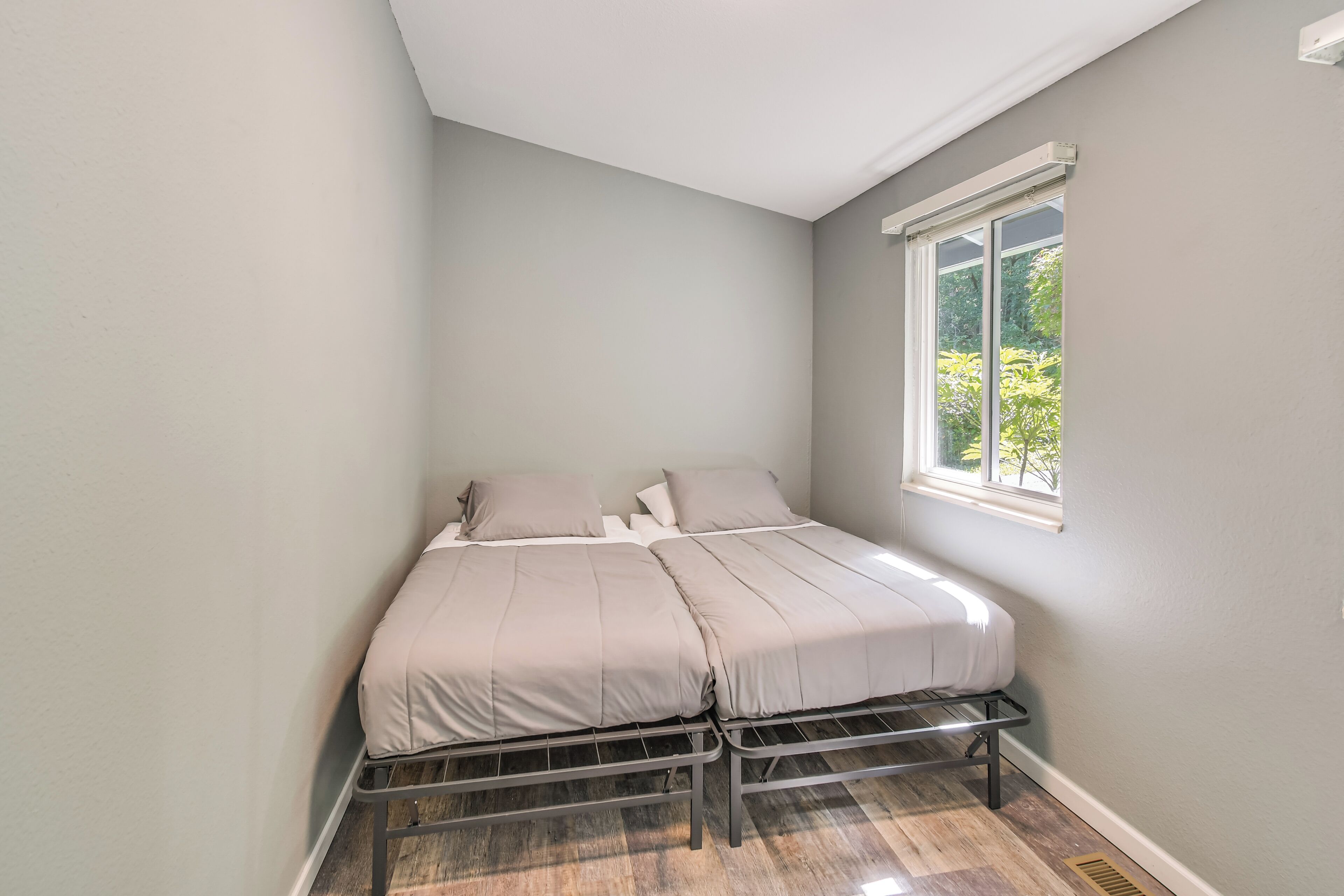 Une chambre à coucher avec un lit, une fenêtre et une vue sur la verdure.