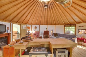 Um interior acolhedor com teto de madeira, área de jantar, sofá e uma kitchenette.