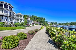 A waterfront residential area with multi-story houses, a sidewalk, and a dock. - Sun, Sand & Boating Fun! Extended Macatawa Getaway (Macatawa)