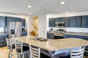 A modern kitchen with granite countertops, stainless steel appliances, and dark cabinetry. - Sun, Sand & Boating Fun! Extended Macatawa Getaway (Macatawa)