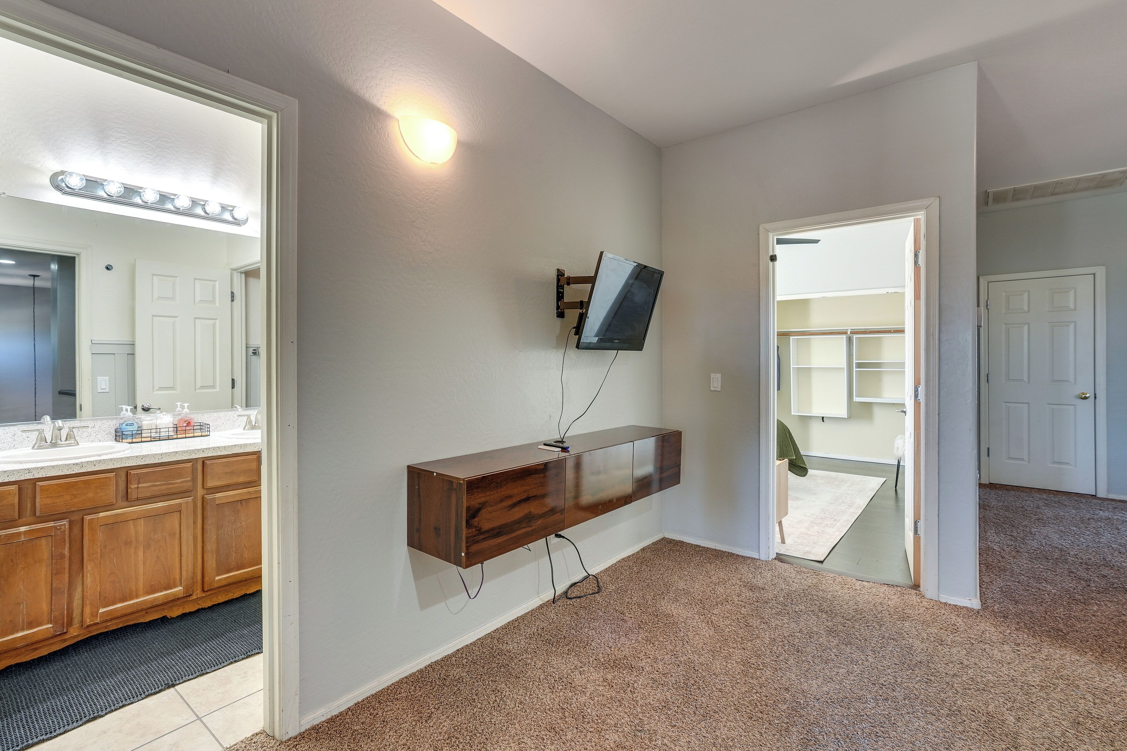 A bathroom with a vanity, mirror, and light fixture.