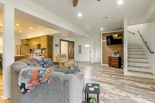 A spacious living area with a sofa, a small table, and a staircase leading to another level.
