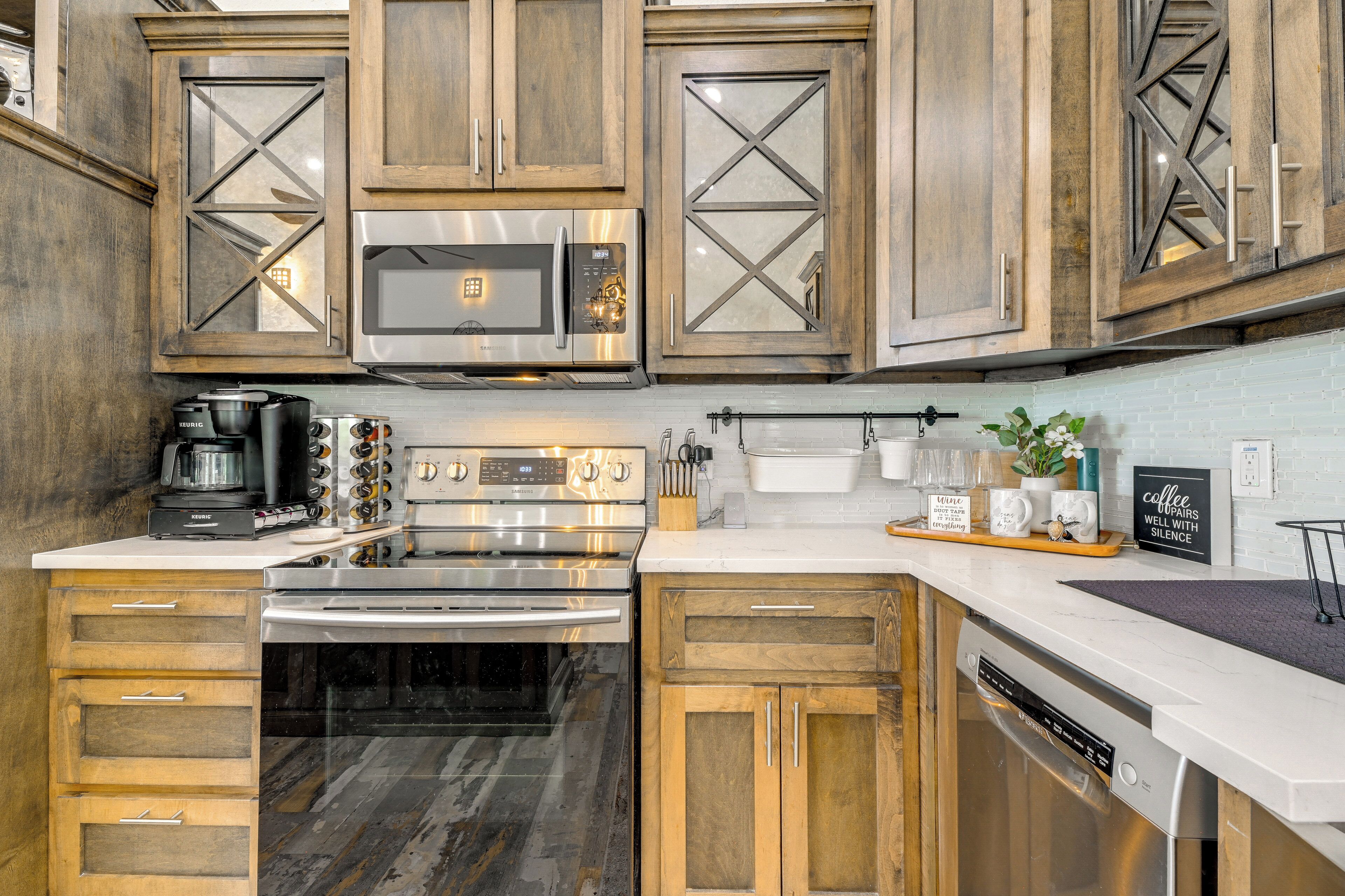 A kitchen with wooden cabinets, stainless steel appliances, and a white countertop.