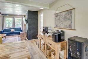 Ein gemütlicher Wohnbereich mit einem blauen Sofa, einer Kaffeemaschine und einer Karte an der Wand.