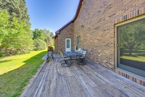 A patio with a table and chairs, a door, and a large window.