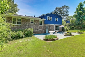 A two-story house with a brick facade, a blue upper section, and a patio with outdoor furniture. - 7 Mi to Stone Mtn Park! Spacious Family Getaway (Lilburn)