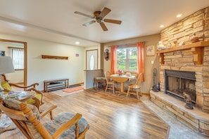 A spacious living room with a fireplace, wooden furniture, and a stone accent wall.