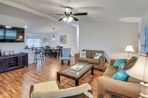 A living room with a sofa, coffee table, and a TV mounted on the wall. - Near Boat Ramp, Kingfisher Park/pier, Dog Friendly (Port O Connor)