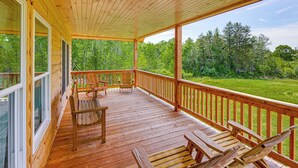 A wooden deck with a railing, benches, and a view of a forest. - Hike, Hunt & Golf! Cabin on 4 Acres in Naples (Naples)