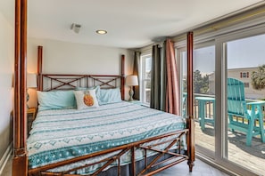 A room with a bed, a window, and a view of outdoor chairs. - Red, White & Beach! 5BR Atlantic Beach Cottage (Atlantic Beach)