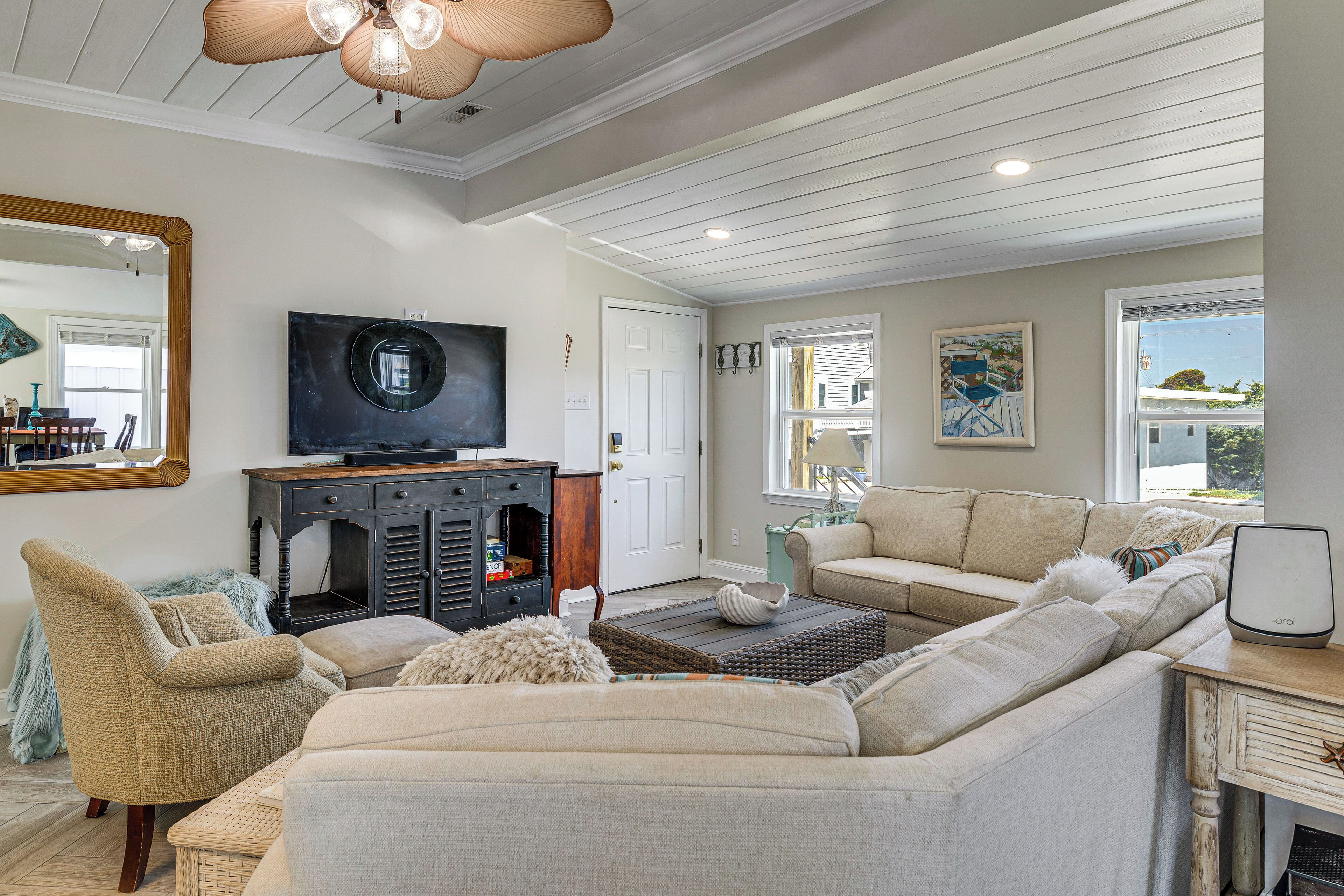 A living room with a sectional sofa, a television, and a fireplace.
