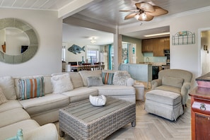 A living room with a sectional sofa, a chaise lounge, a coffee table, and a wicker ottoman. - Red, White & Beach! 5BR Atlantic Beach Cottage (Atlantic Beach)