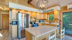 Una cocina moderna con armarios de madera, electrodomésticos de acero inoxidable y una isla grande con asientos.