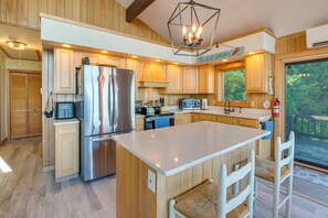 Una cocina moderna con armarios de madera, electrodomésticos de acero inoxidable y una isla grande con asientos.