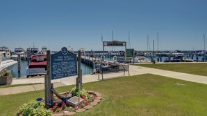 A marina with boats, a sign for Port San Jacinto Harbor Refuge, and a small pavilion. - Cute Cottage Getaway; Walk to Lake and Town (Port Sanilac)