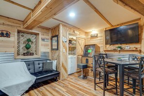 A cozy cabin interior with a sofa, dining table, and a washing machine.