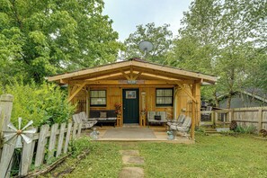 A wooden cabin with a porch, a welcome sign, and a satellite dish.