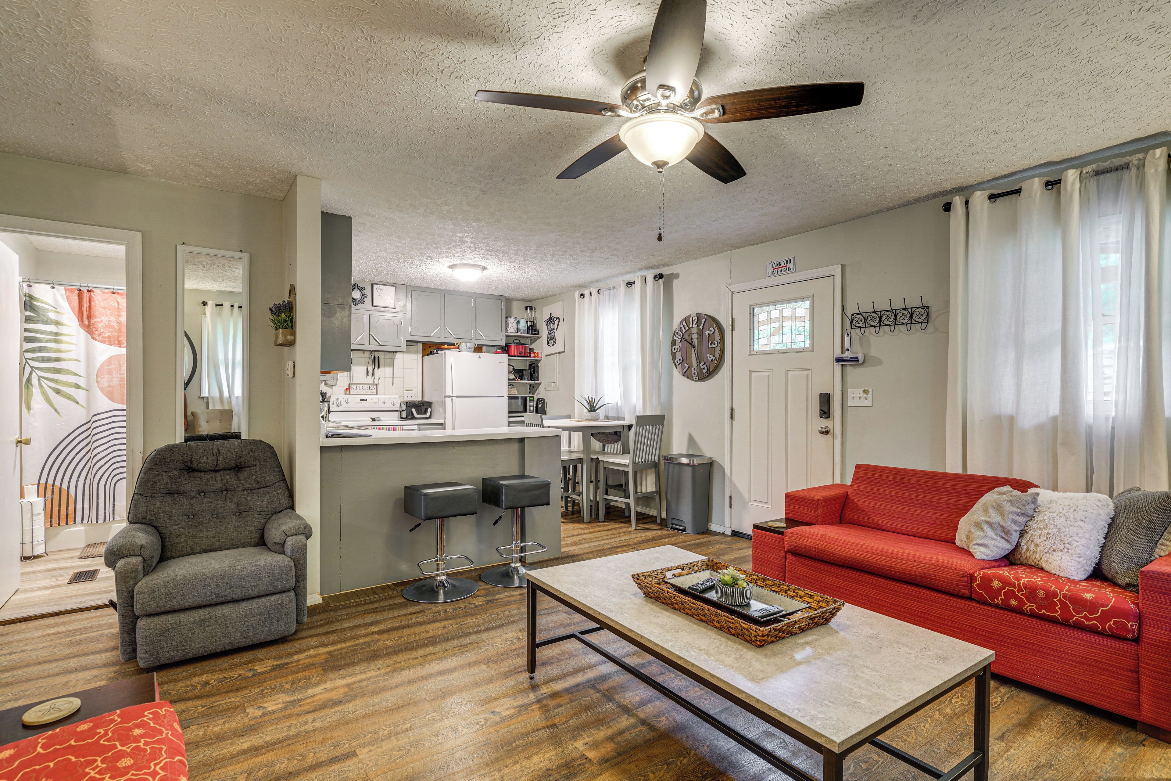 A living room with a red sofa, grey armchair, and a coffee table.