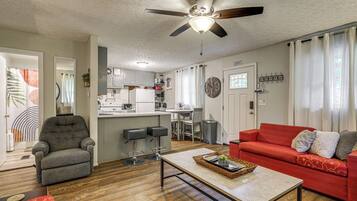 A living room with a red sofa, grey armchair, and a coffee table.