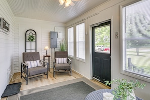 A room with two chairs, a table, a door, and a window.